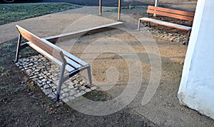 Under the bench are rectangles made of tiles. otherwise, the soft surface of the compacted gravel park path could erode the shoes