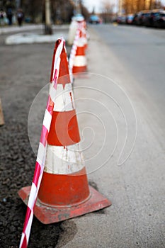 Under construction board sign on the closed road with arrow sign and traffic cone.