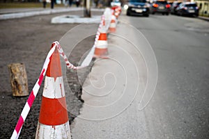 Under construction board sign on the closed road with arrow sign and traffic cone.