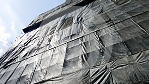 Under construction building that covered by black canvas