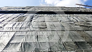 Under construction building that covered by black canvas
