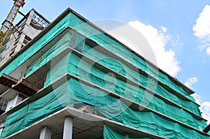 Under construction building covered with green net for safety