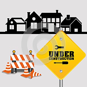 under construction sign with cone barrier traffic and houses