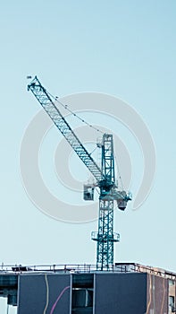 Under construction, a tall building with a gray construction crane