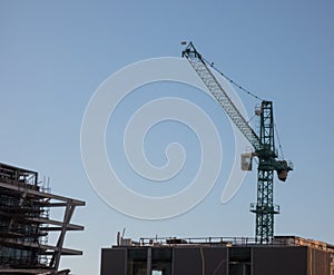 Under construction, a tall building with a gray construction crane