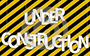 Under Construction text hanging on ropes on a yellow and black background