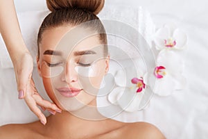 Under eye treatment. Woman with patches, relaxing in spa center