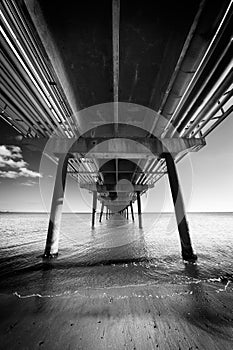 Under the jetty with pylons in perspective, in black and white. Cagliari, rumianca jetty.