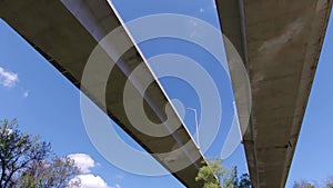 Under large two-lane concrete bridge, tilt up and pan right.