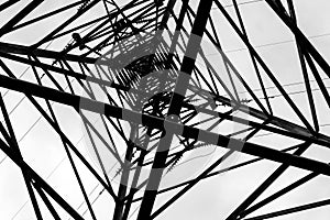 Under overhead high-voltage power line tower. View from bottom of construction