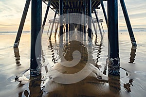 Under the pier. An old wooden Pismo Beach pier at sunset, CA