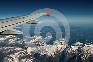 Under plane wing snow-covered mountain tops. Austria-Italy