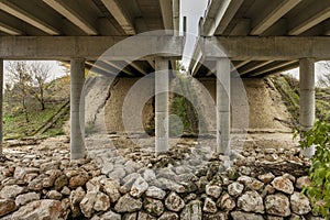 Under a road bridge with two independent carriageways with circular concrete pillars