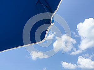 Under umbrella looking at bright blue sky