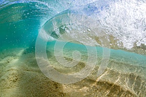 Under water view of Small wave breaking over sandy beach at waimea bay hawaii
