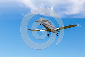 The underbelly view of the tail, body, wings, nose and propeller of Piper PA-25 Pawnee tow aircraft in the air