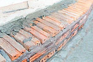 Underconstruction staircase made by red brick and cement.