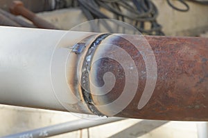 Undercooked weld butt covered with slag. Piping during manual arc welding using an electrode. Installation and welding of