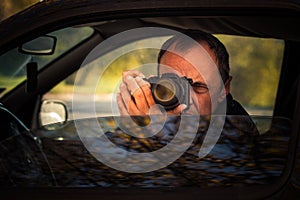 Undercover man hidden in car take photo