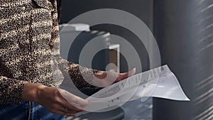 An undercover spy examines confidential documents in the office. Female hands leafing through confidential documents