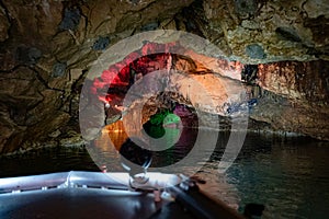 Underground cave lake boat with colorful lighted walls