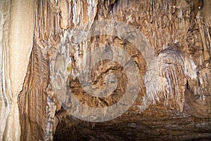 underground cave with many stalactites and stalagmites of different shapes, speleology photo