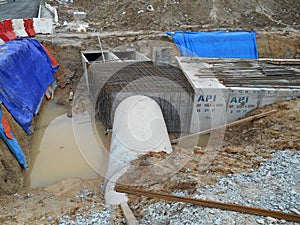 Underground drainage manhole under construction by construction workers at the construction site.