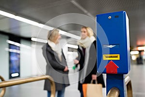 Underground entrance with turnstile. Two unrecognizable women.