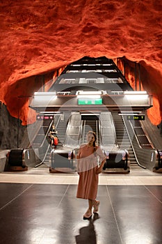 Underground metro tunnelbana station Solna Centrum with escalator and black red like fire caves walls and ceiling