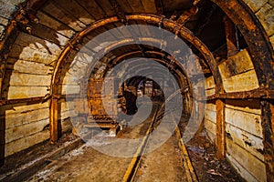 Underground mining tunnel with rails. Abandoned coal mine. Tunnels and passages in a coal mine