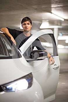 Underground parking garage - young male driver with his small city electric car