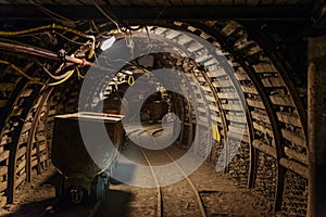 Underground train in black coal mine tunnel photo