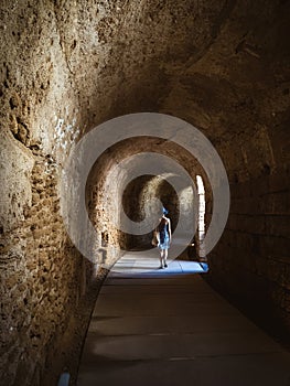 Underground tunnel at the Roman Theatre of CÃÂ¡diz with a young woman in sundress walking through photo