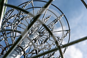 Underneath a disc golf goal looking up with selective focus on the chain basket.