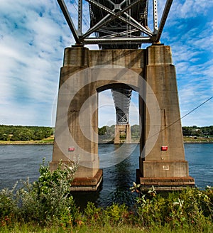 Underneath Sagamore bridge spans Cape Cod Canal showing the heavy cement footings piers