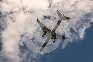 Underside of flying airplane in blue cloudscape at Nawiliwili airport, Kauai, Hawaii, USA