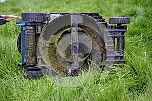 Underside of a Lawn Mower in long grass