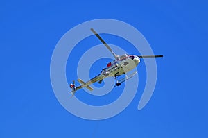 Underside of utility helicopter with lifting cable