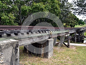 The underside view of an old timber railway bridge crossing the Barron River