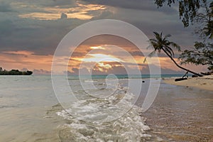 undertow of the sea at the beach with tropical sunset photo