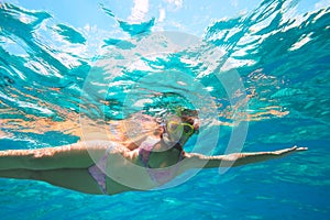 Underwater adventure of a young girl in the tropical sea