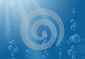 Underwater air bubbles on  blue background. Water background with sunlight and vertical streams of air bubbles.