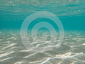 Underwater blue ocean wide background with sandy sea bottom, Real natural underwater view of the Mediterranean Sea