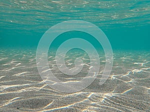 Underwater blue ocean wide background with sandy sea bottom, Real natural underwater view of the Mediterranean Sea