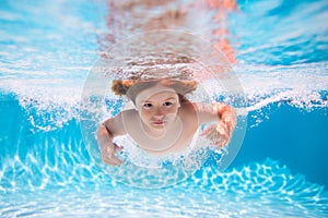 Underwater boy in the swimming pool. Cute kid boy swimming in pool under water. Beach sea and water fun.