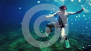 Underwater diving. Relaxation, sport, sunlight, travel, healthy lifestyle. Guy is diving under water. Summer vacation concept.