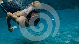 Underwater. father and his daughter swim in the pool on dad`s day