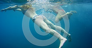 Underwater, friends and swimming in ocean, relax and travel for fun, summer holiday and break. Water, women and bikini