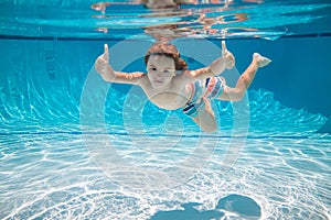 Underwater kid swim under water. Child boy swimming and diving underwater in pool. Summer family summer vacation with