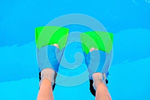 Underwater kids legs in fins in swimming pool, top view. Mockup with copy space